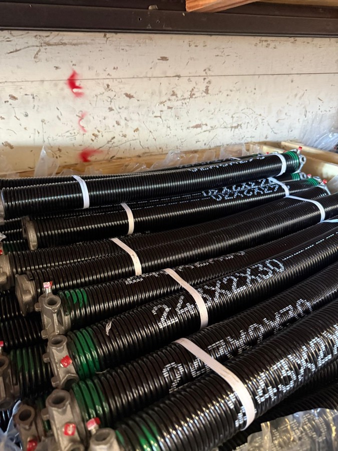 Rack of new torsion springs stocked on the service truck